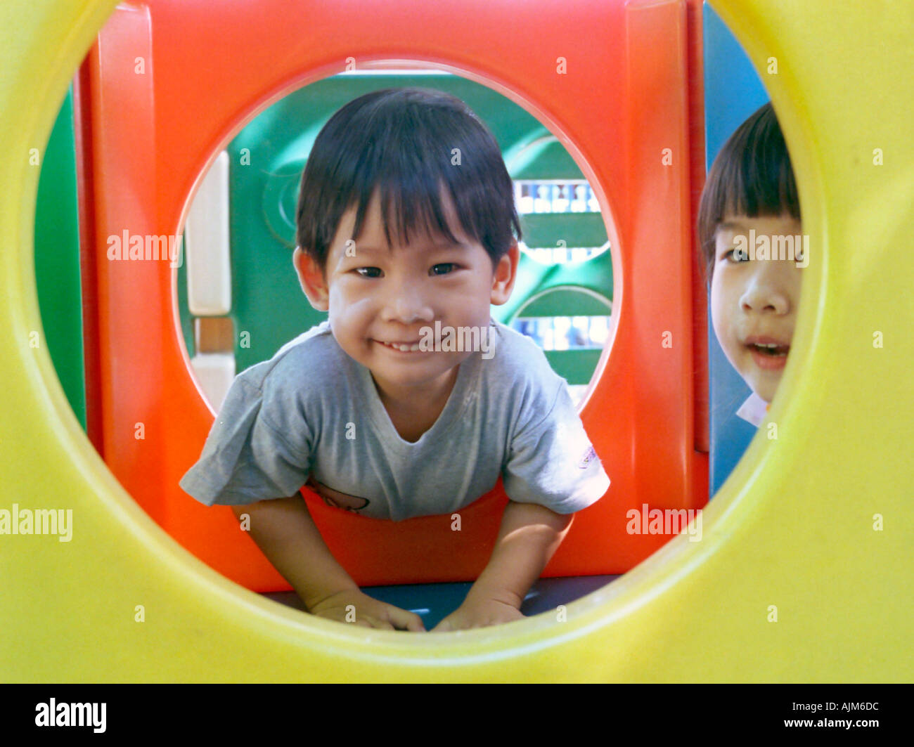 Boy and girl are playing in the colourful playground Stock Photo - Alamy