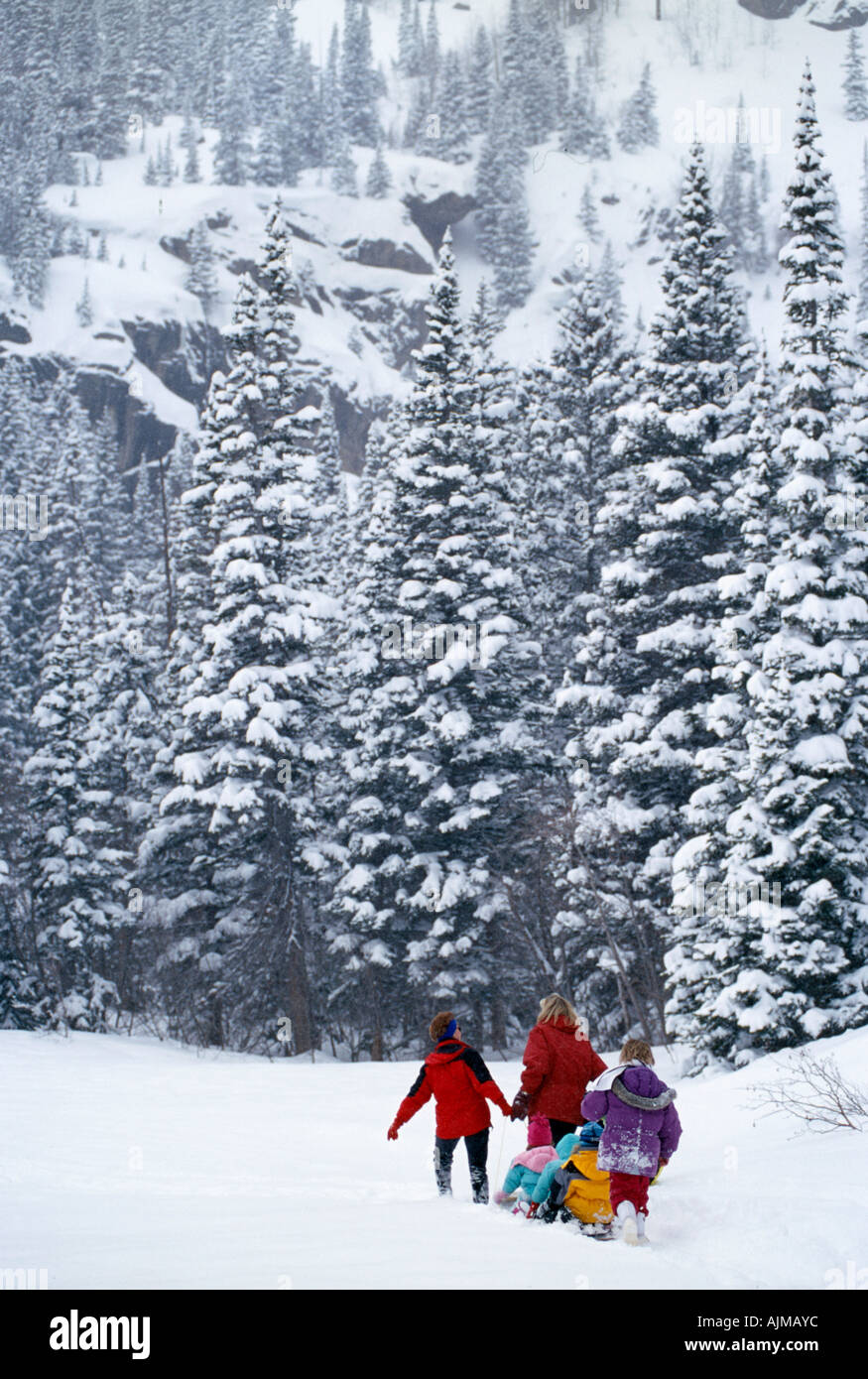 Family crossing deep snow with tobaggan Rocky Mtns CO Stock Photo