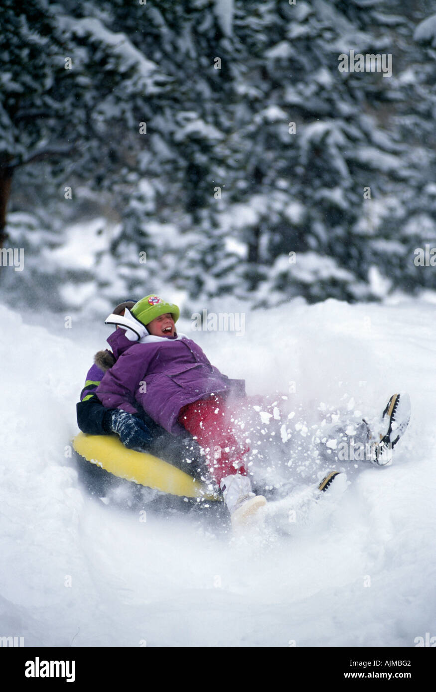Father daugther tubing in fresh snow Rocky Mtns CO Stock Photo