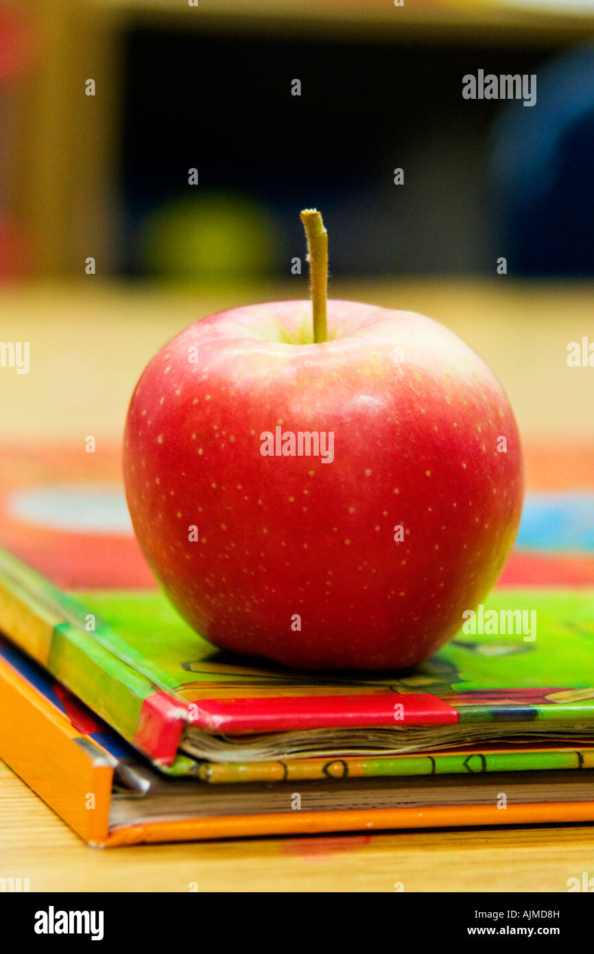 Apple on stack of two school books Stock Photo