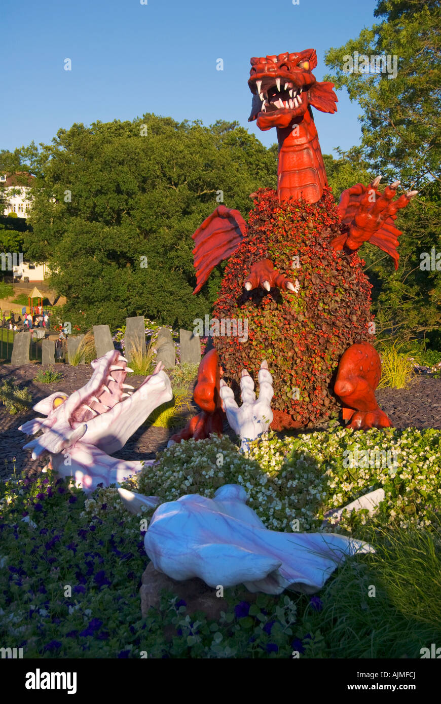 red dragon kills white dragon in a flower bed in the park Stock Photo