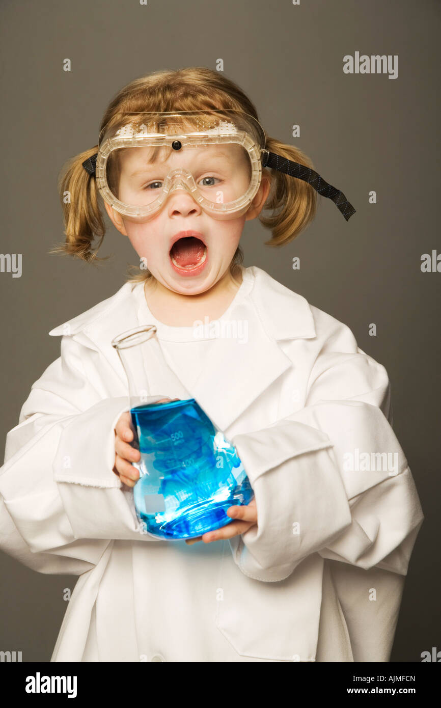 Little girl with safety goggles and lab coat holding a science beaker