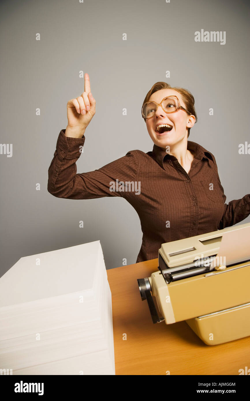 Office worker raising hand at desk Stock Photo - Alamy