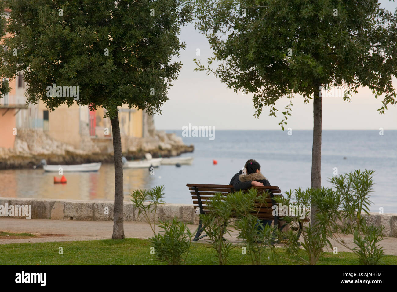 Loving couple sitting on seaside in Old town Rovinj in Croatia Stock Photo