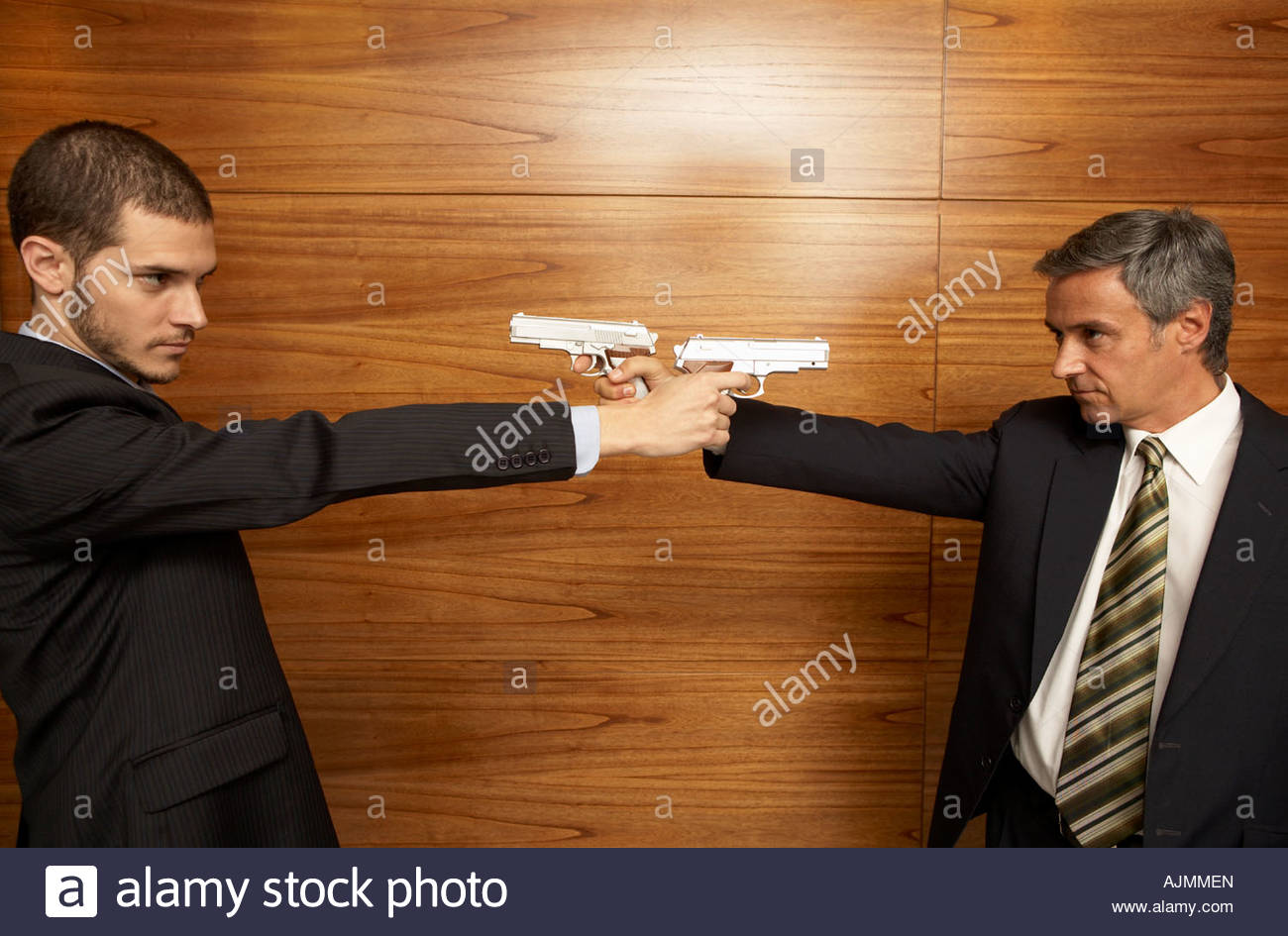 two-businessmen-pointing-guns-at-each-other-AJMMEN.jpg