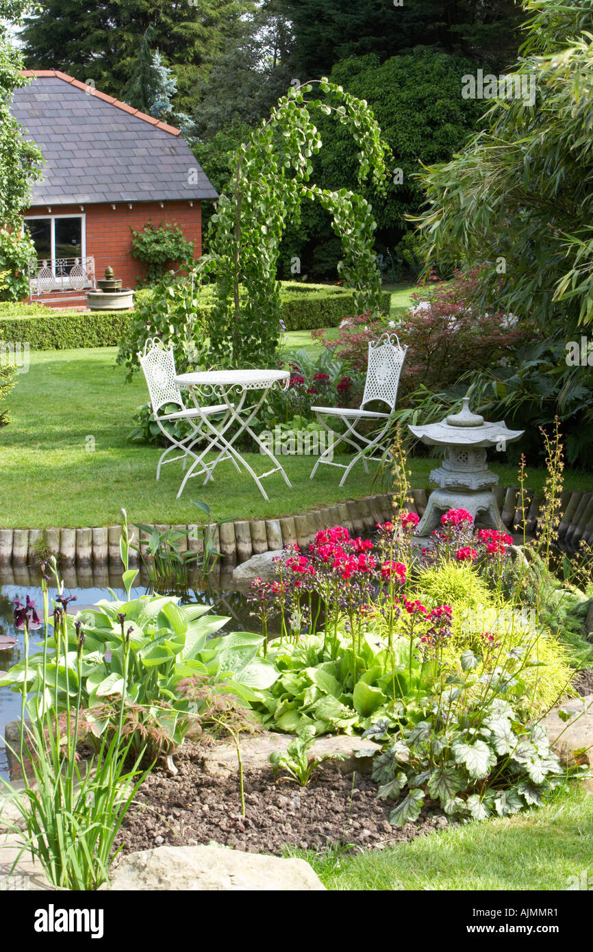 garden furniture with pool and bog garden at Cypress House Dalton Stock Photo