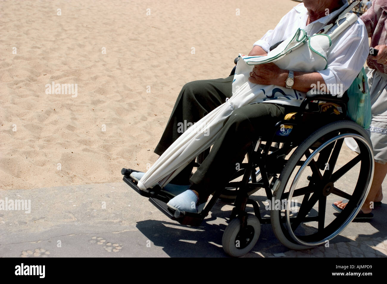old senior invalid man in wheelchair near the beach Stock Photo