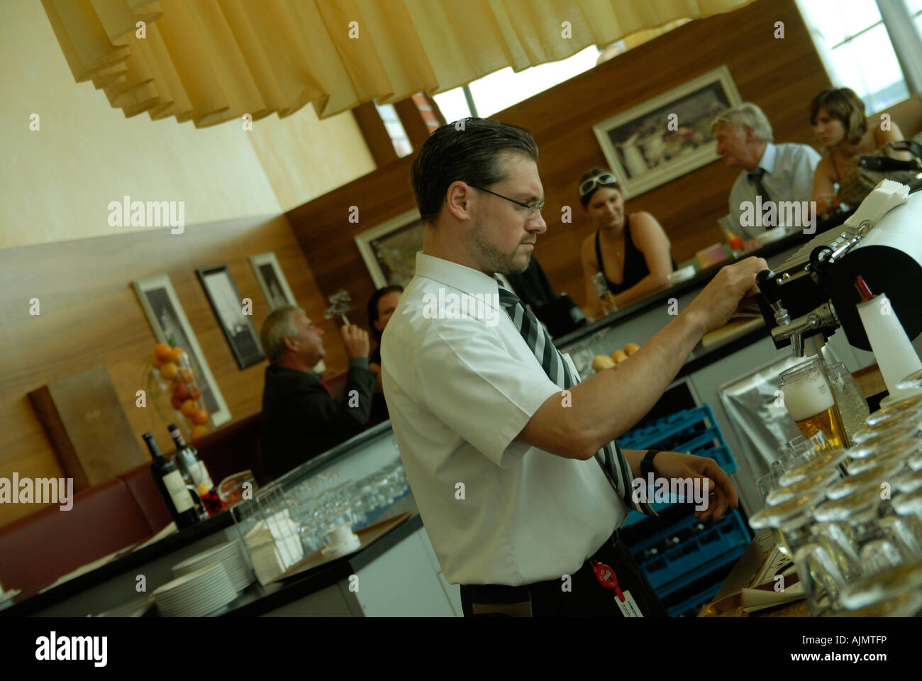 Barman pouring beer into a glass at a restaurant at Graz international airport Austria Stock Photo