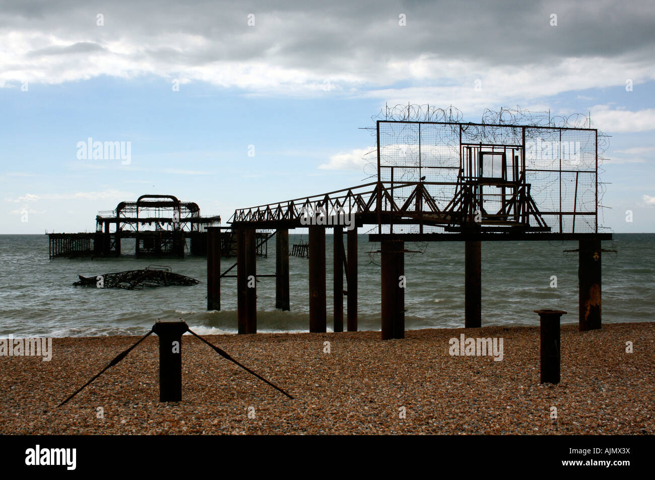 Remains of the old west pier on cold and wet day on beach in Brighton, England, UK Stock Photo