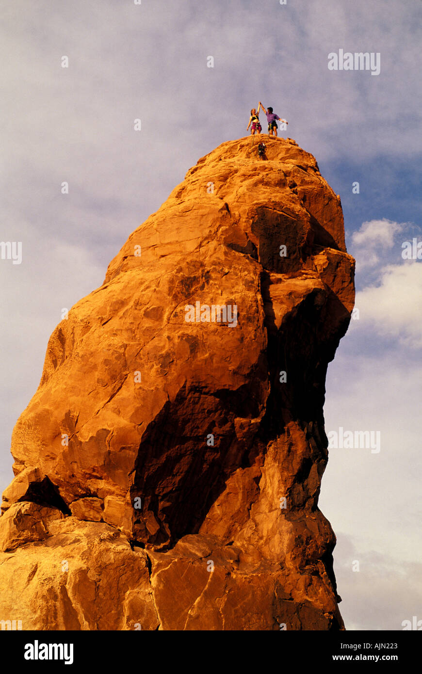 A couple of rock climbers celebrate their successful ascent of a ...