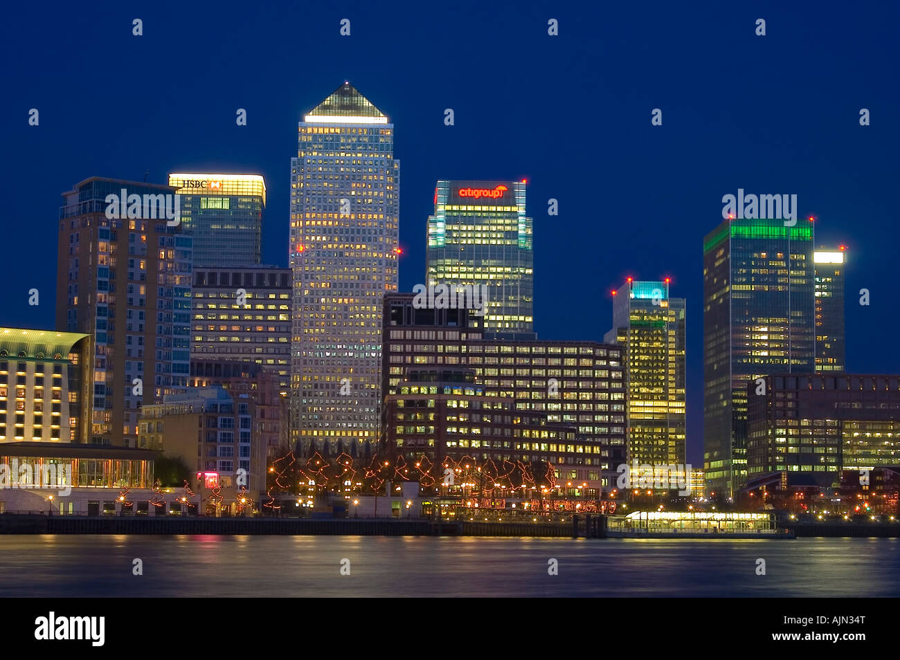 canary wharf shot from across the river thames night evening illuminated office blocks london england uk europe Stock Photo