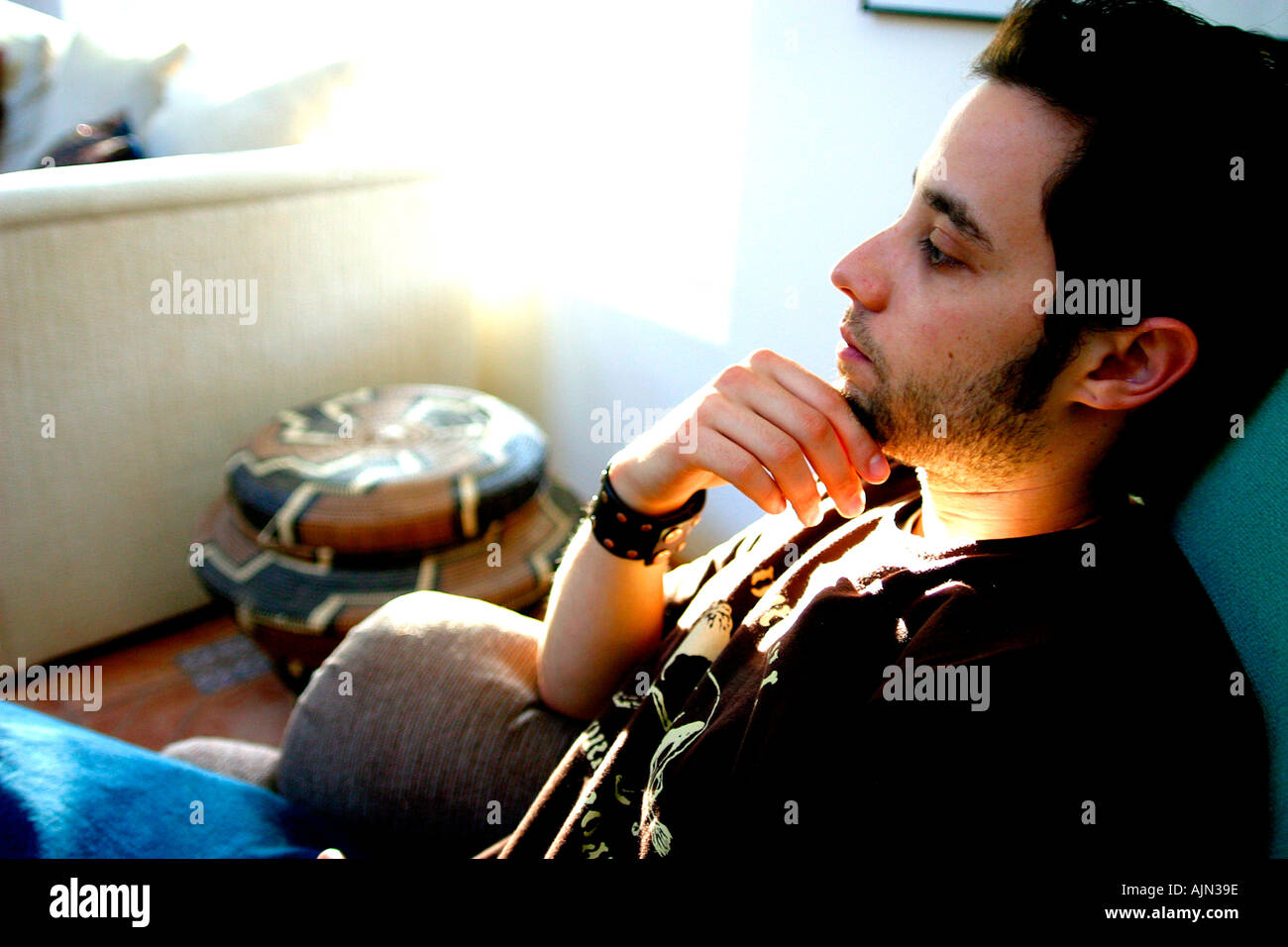 YOUNG MAN RELAXING AT HOME Stock Photo