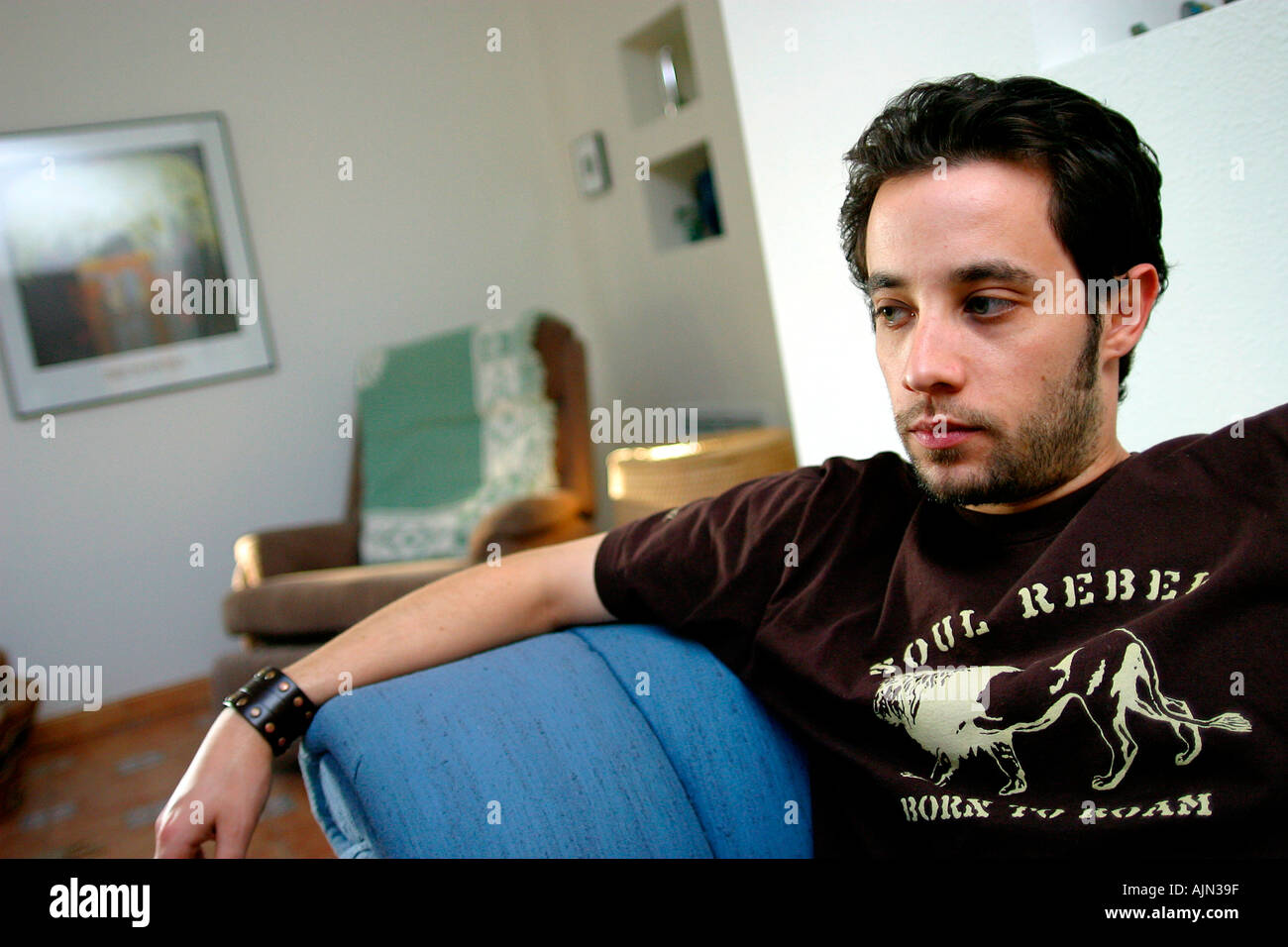 YOUNG MAN RELAXING AT HOME Stock Photo