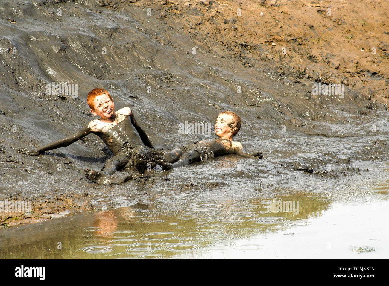 Boys playing in Mud Stock Photo Alamy