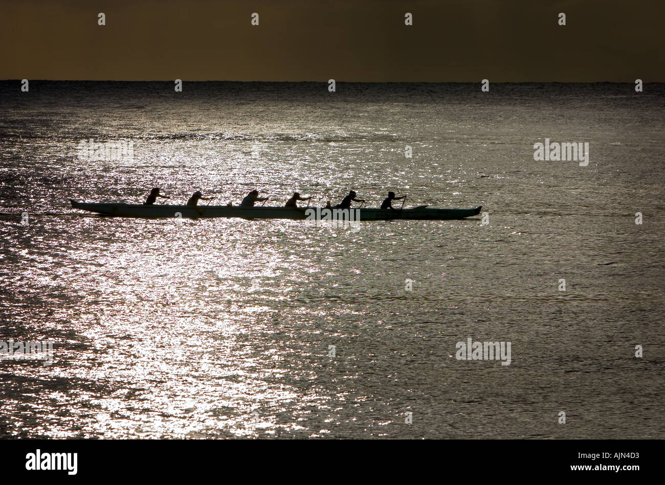 Ladies rowing boat team north shore Hawaii in sunset Stock Photo