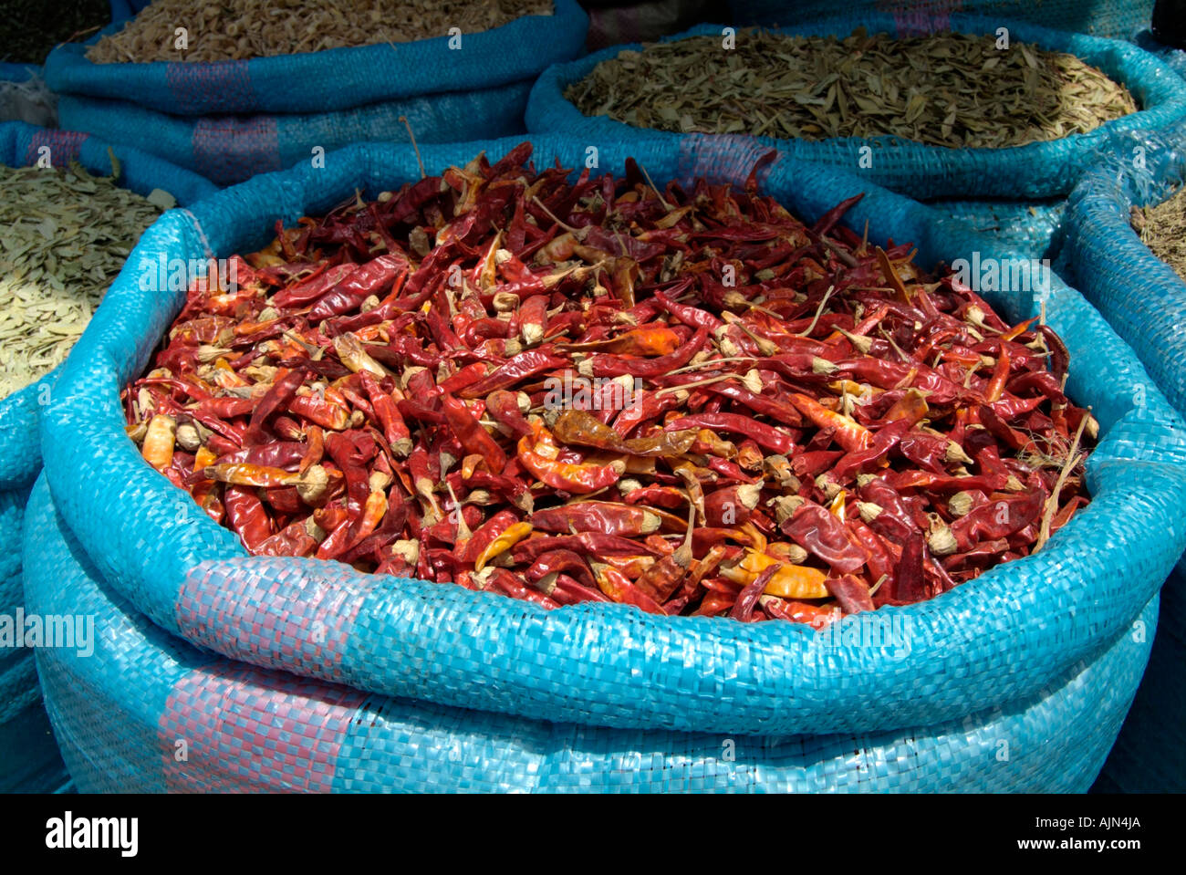 Blue sacks filled with spices and dried herbs for sale in a market in Tangiers Stock Photo