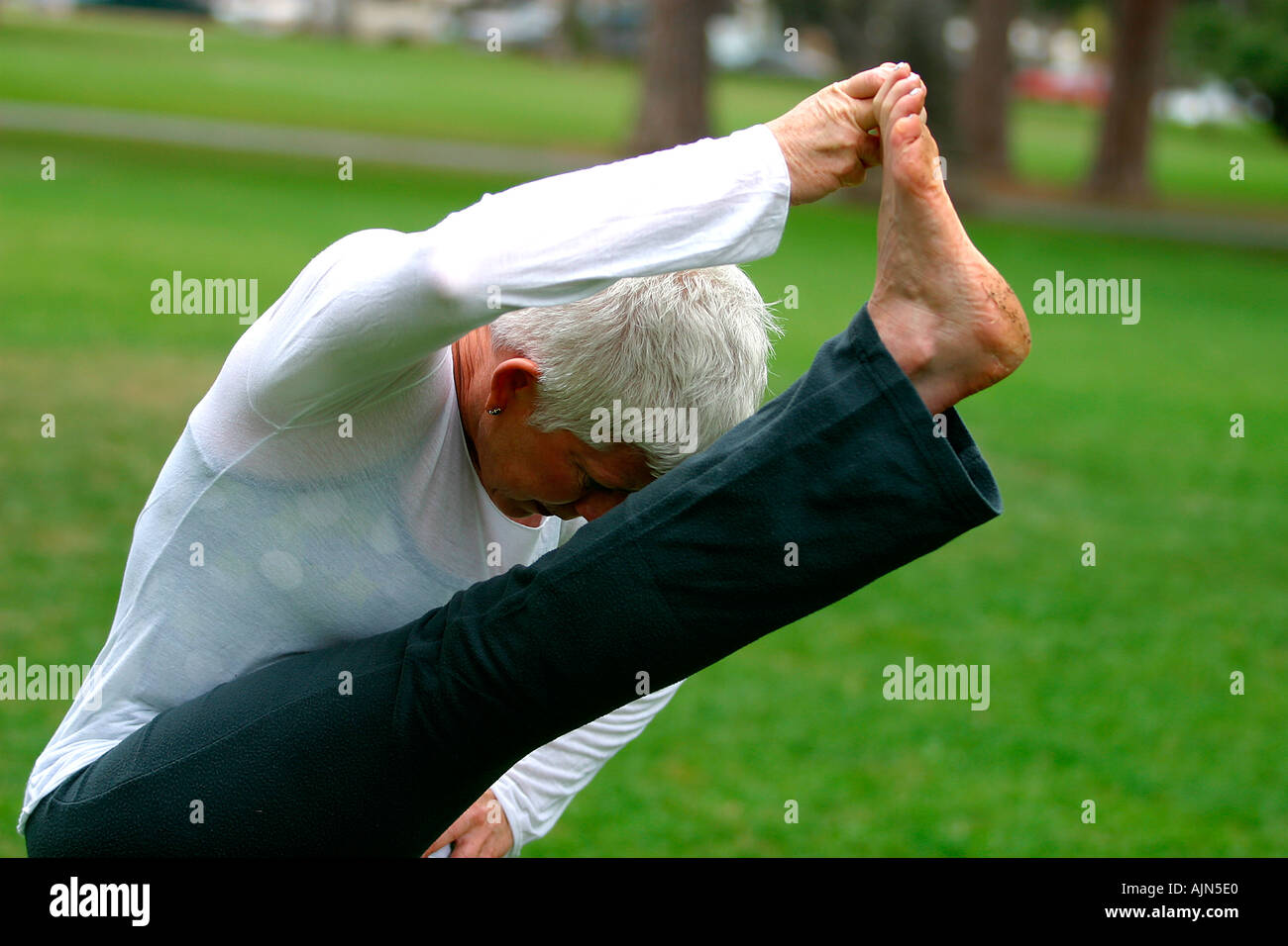 MIDDLE AGED WOMAN DOING YOGA EXERCISE Stock Photo