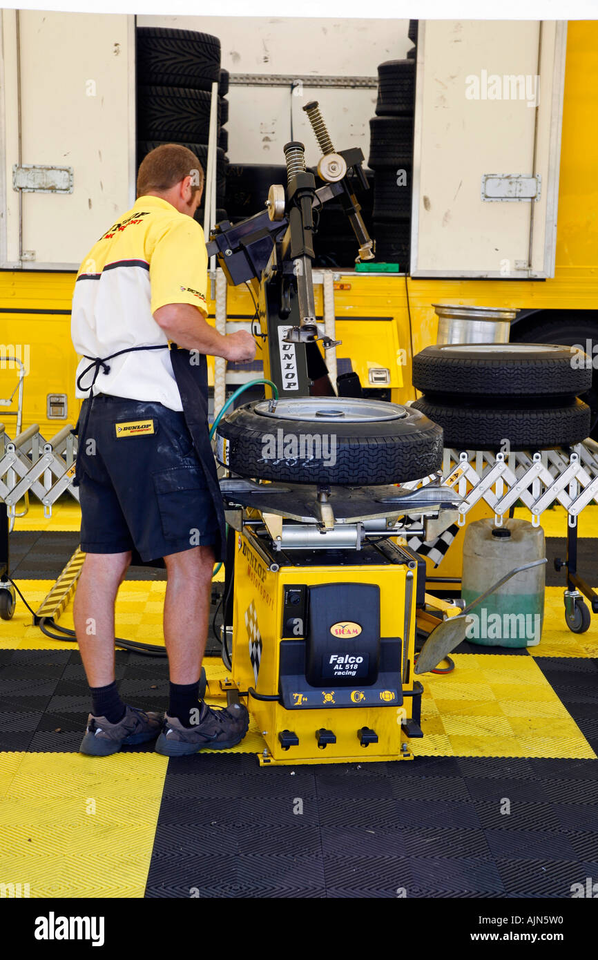 Tyre fitter attaching a tyre to a car race wheel. 2006 Stock Photo Alamy