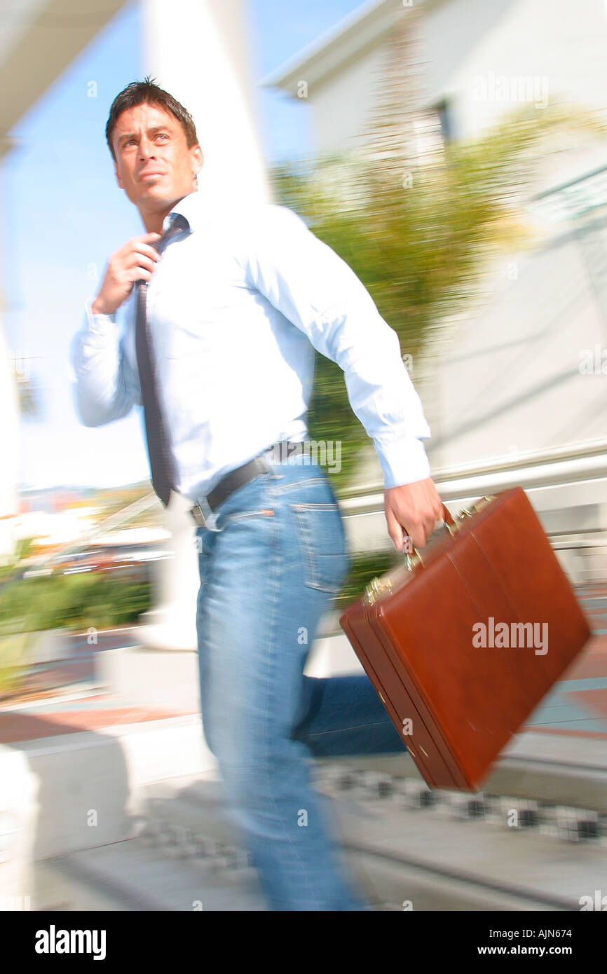 CASUALLY DRESSED BUSINESSMAN WALKING WITH BRIEFCASE Stock Photo - Alamy