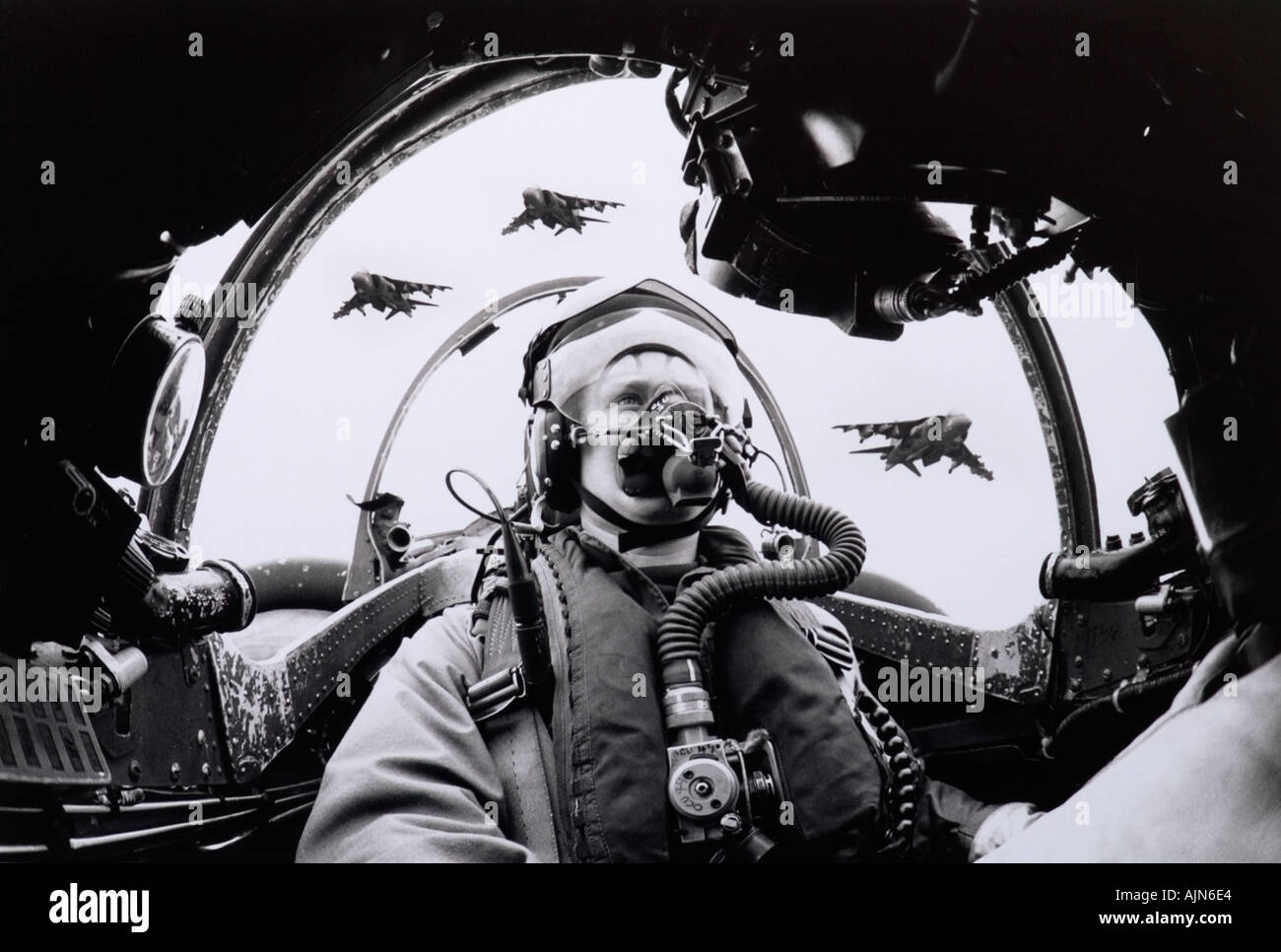 Pilot Officer Bill Auckland at the controls of an RAF Harrier GR3 VTOL jet fighter with GR5 versions flying overhead. Stock Photo