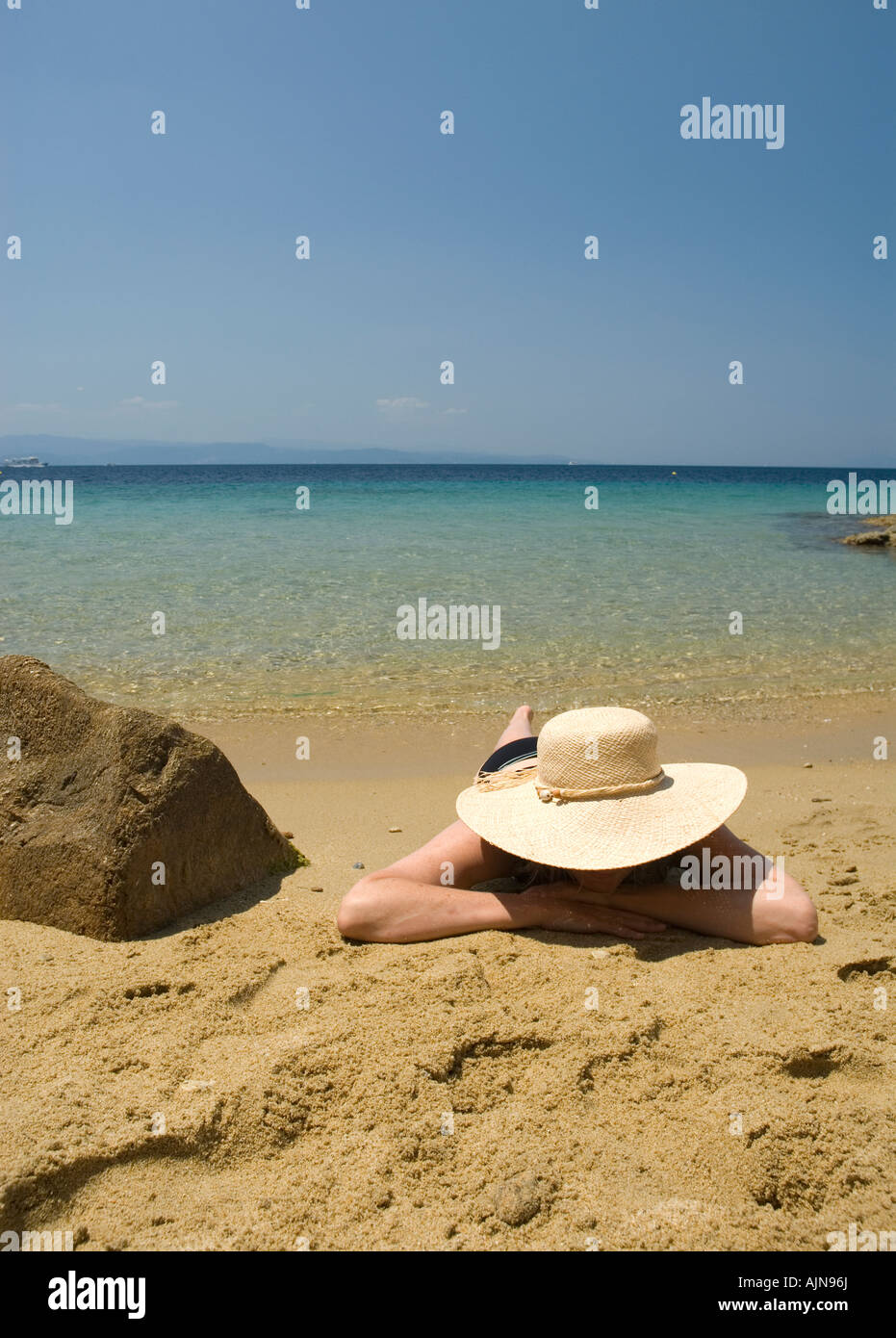 woman female wearing straw hat lying on sandy beach with blue ...