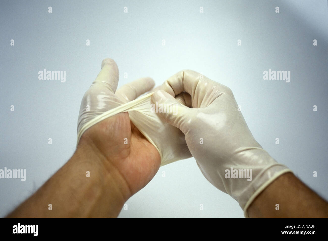 Removing putting on latex surgical gloves Stock Photo - Alamy