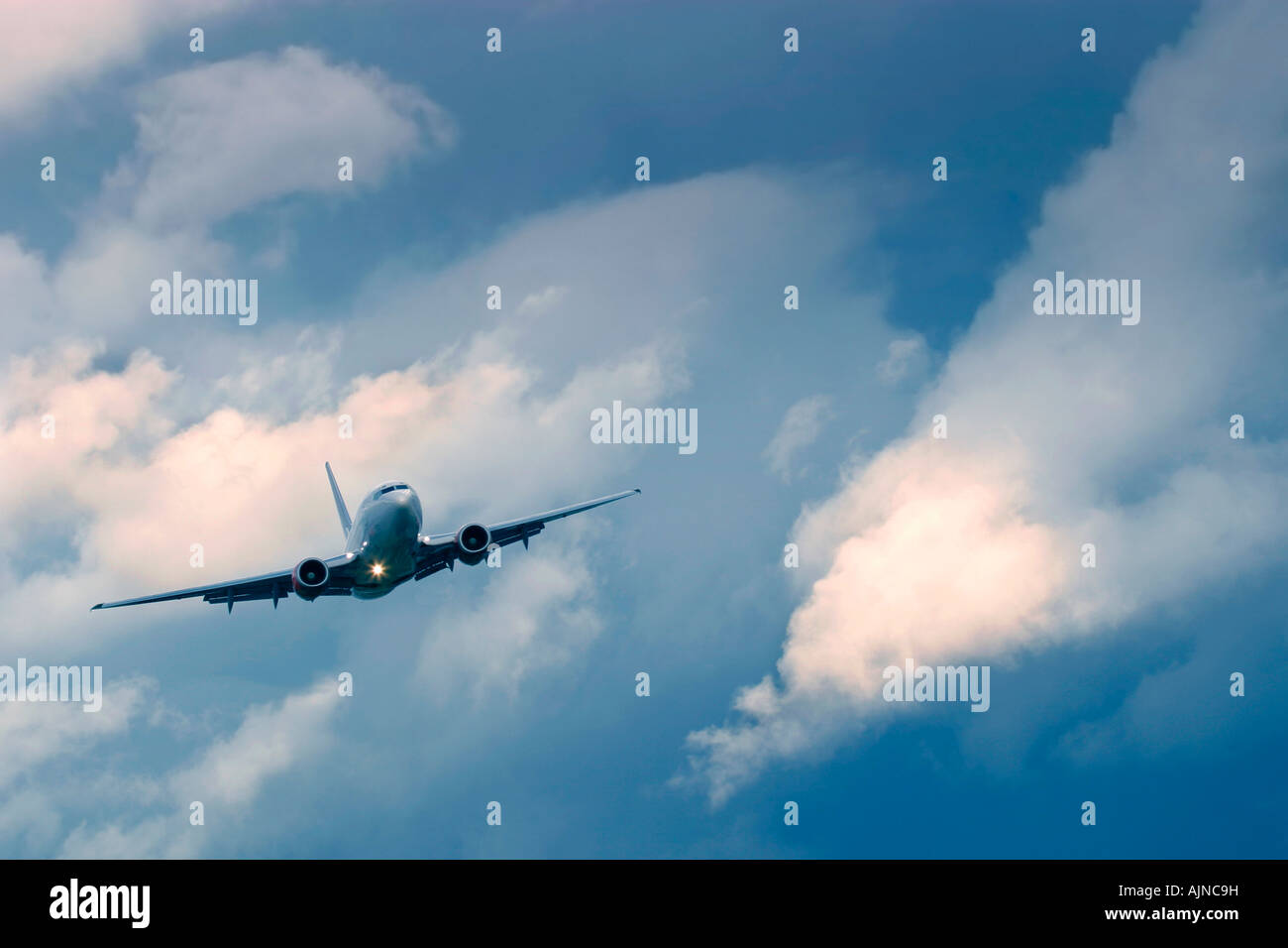 Commercial airplane during flight in the dramatic stormy clouds Stock Photo
