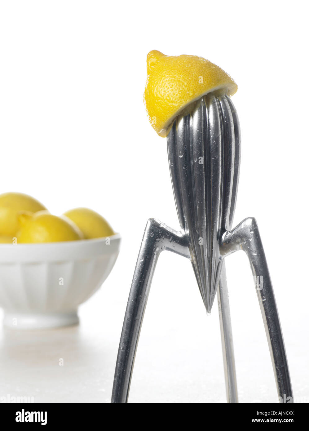lemon juicer with bowl of lemons Stock Photo Alamy