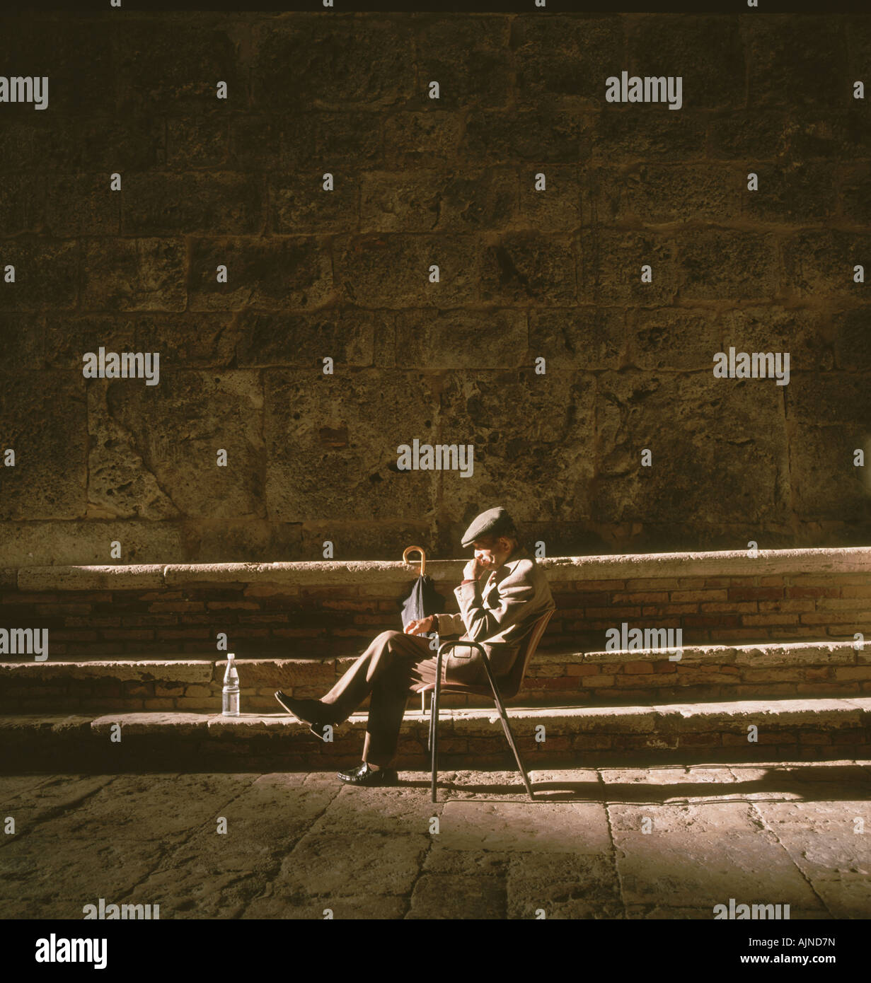 Old Man basking in the sunlight in San Gimingano, Tuscany. Stock Photo