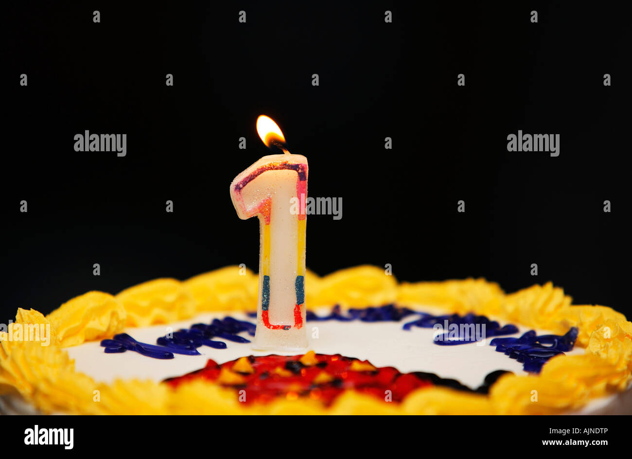 A birthday cake with lit candle Stock Photo - Alamy