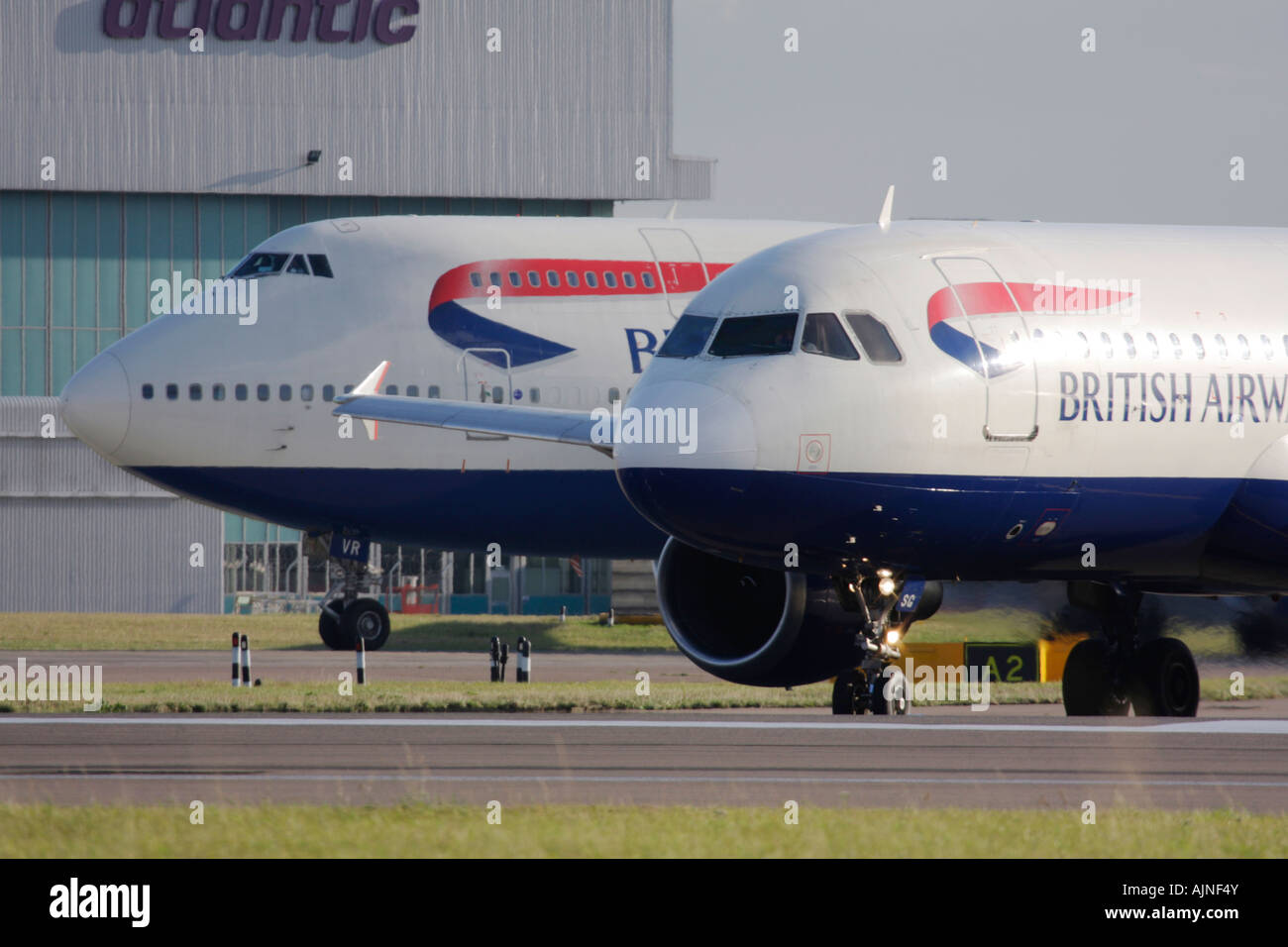 British Airways Airbus A320 and Boeing 747 taxiing for departure at London Heathrow Airport, UK Stock Photo