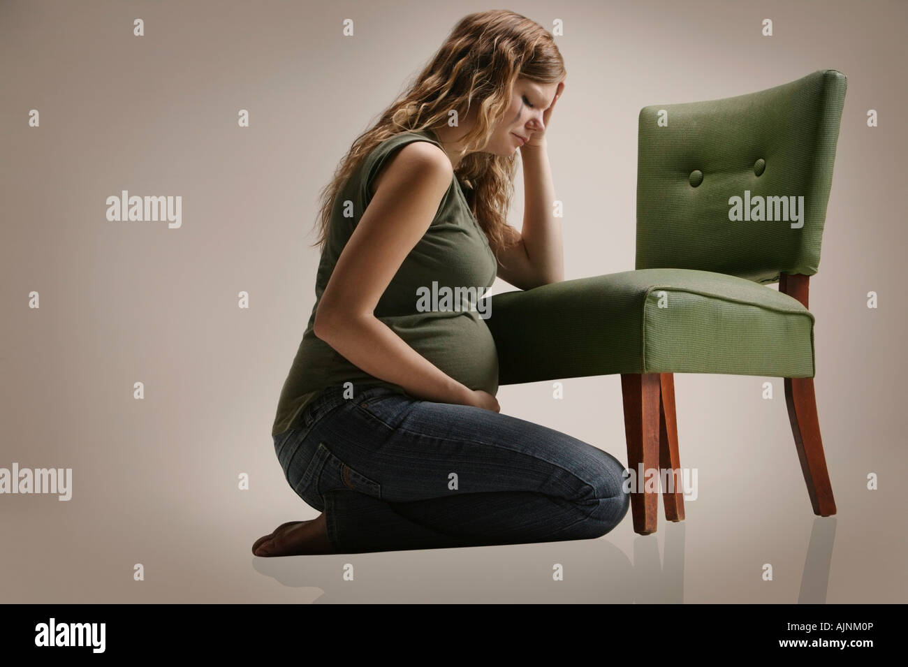 https://c8.alamy.com/comp/AJNM0P/a-sad-pregnant-woman-sitting-by-chair-AJNM0P.jpg