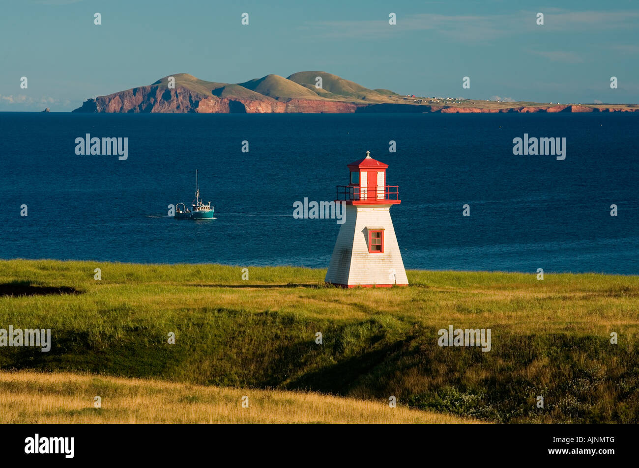 Lighthouse and fishing boat at Cap Alright, Magdalen Islands, Quebec, Canada Stock Photo Alamy