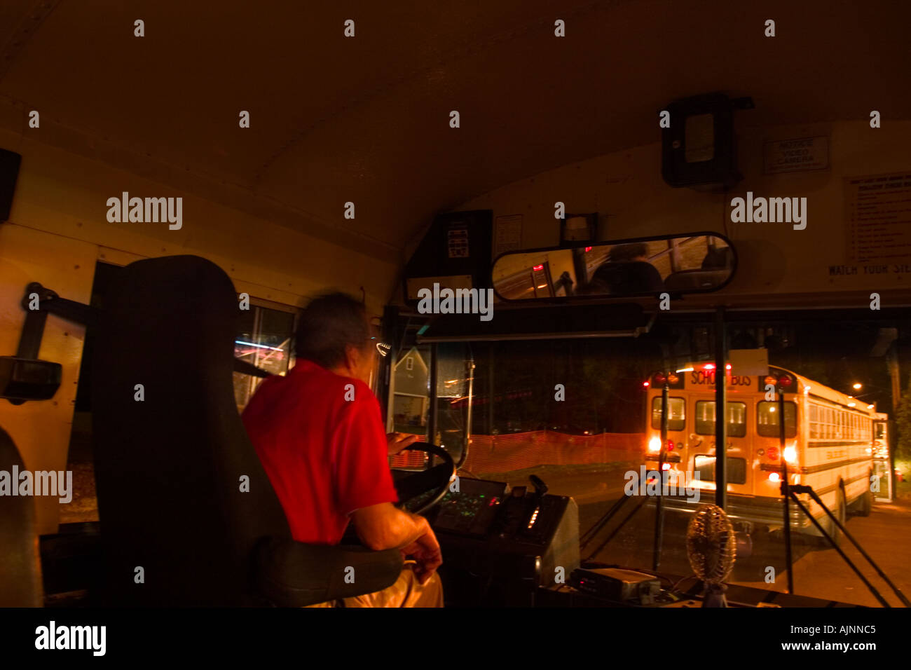 School bus driver at night at a fair looking out his front window at  another school bus Stock Photo - Alamy