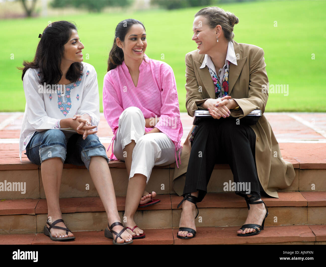 Three young professionals sharing a light moment Stock Photo - Alamy