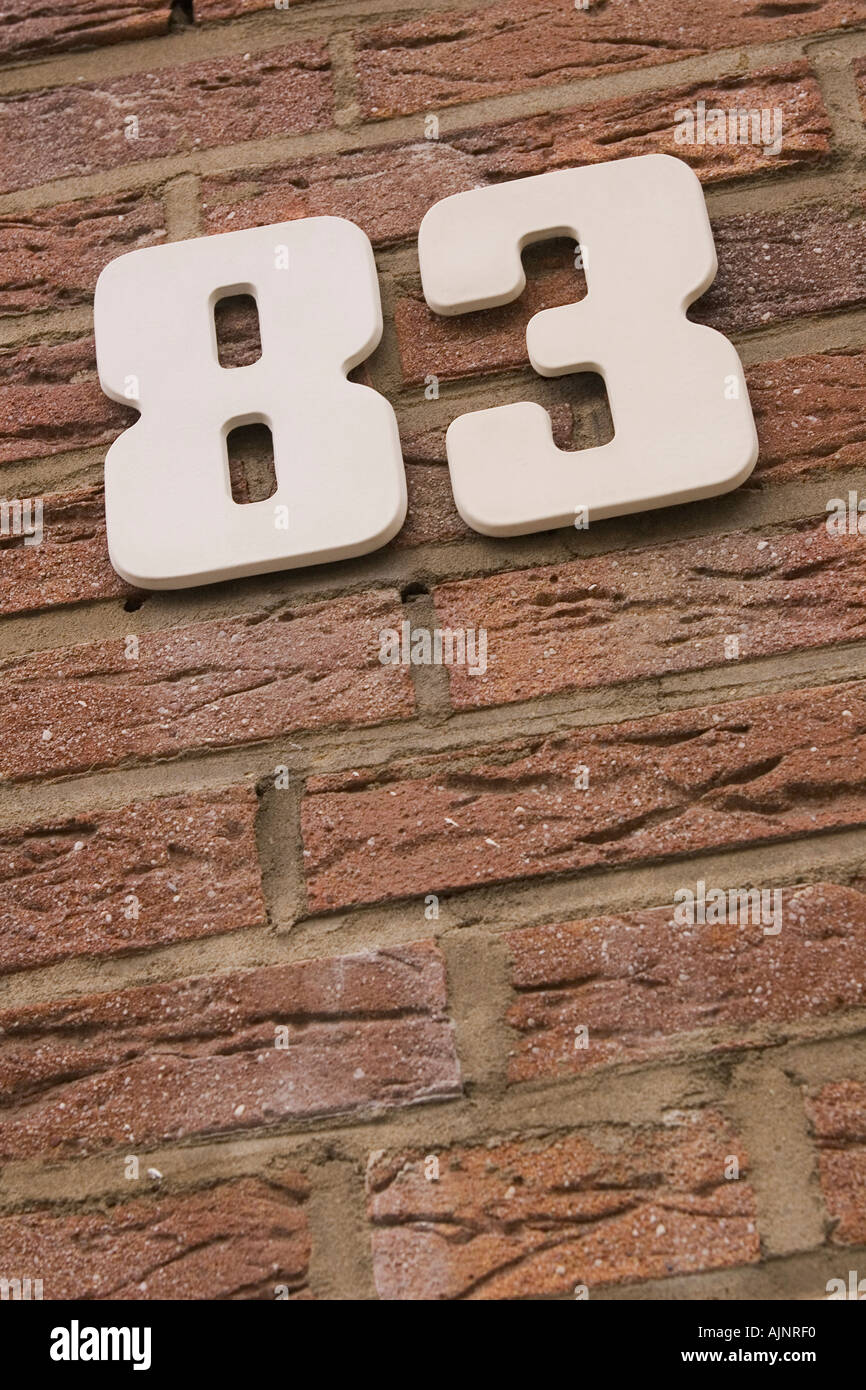 Low angle view of number 69 mounted on a brick wall Stock Photo