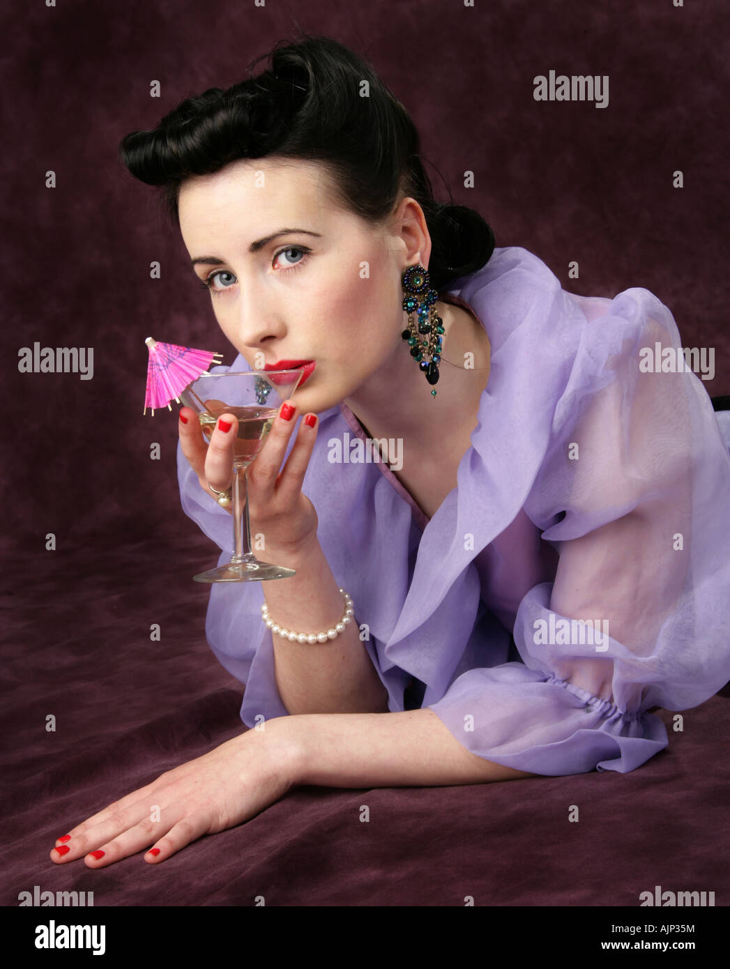 A Pin Up Girl in a Purple Blouse Holding a Cocktail Glass with Pink