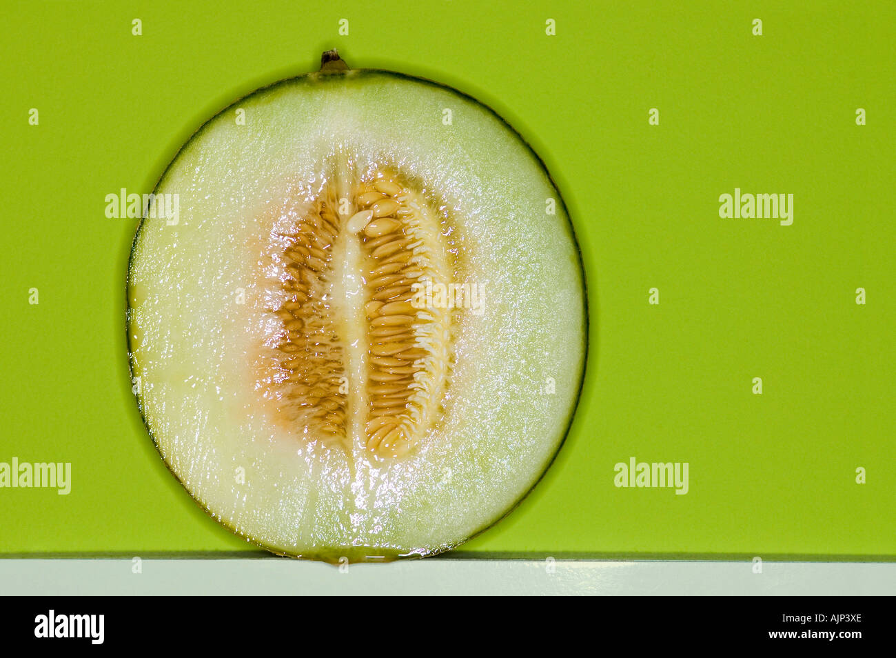 MELON WITH SEEDS ON COLORFUL BACKGROUND Stock Photo