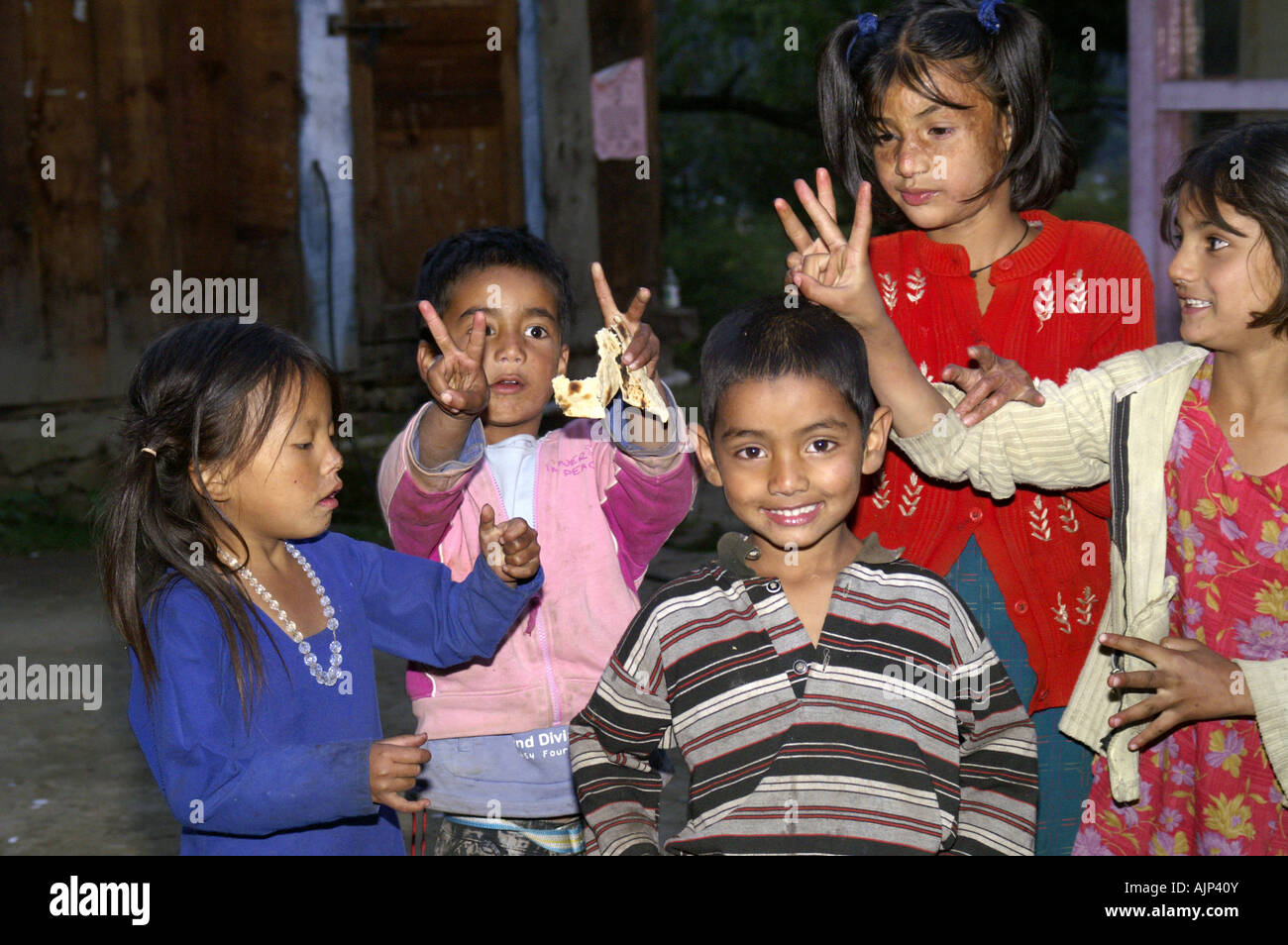 A group of happy smiling indian children boys girls showing victory sign having fun in Kalga village Himachal Pradesh Stock Photo
