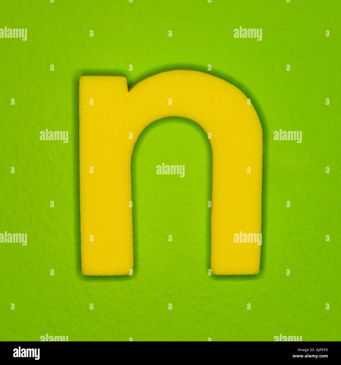 YELLOW ALPHABET LETTER N ON GREEN BACKGROUND Stock Photo
