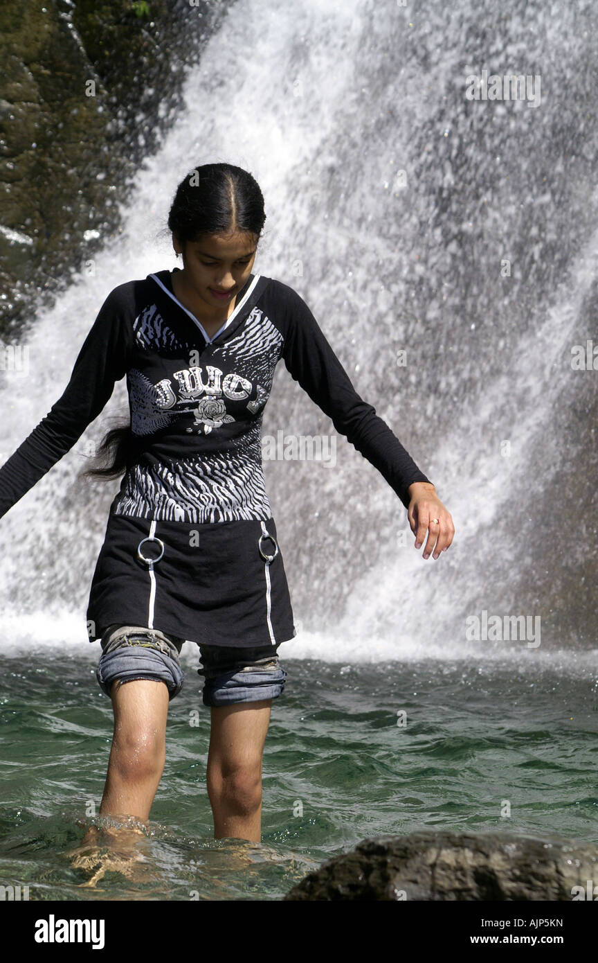 Skinny young indian girl woman walking bare feet in pond under waterfall  outdoors. Bhagsunag, India Stock Photo - Alamy