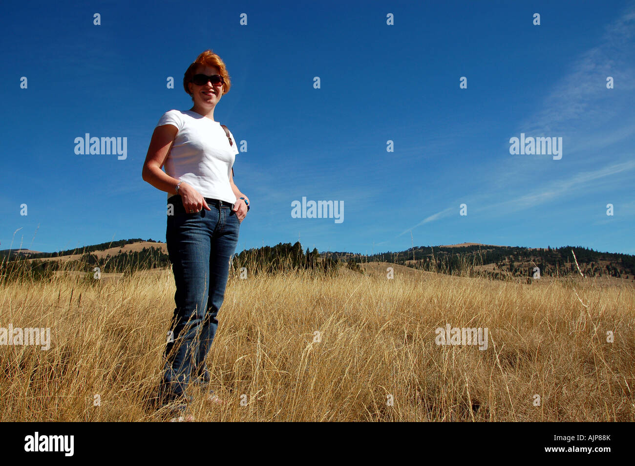 Standing woman in blue shirt hi-res stock photography and images - Alamy