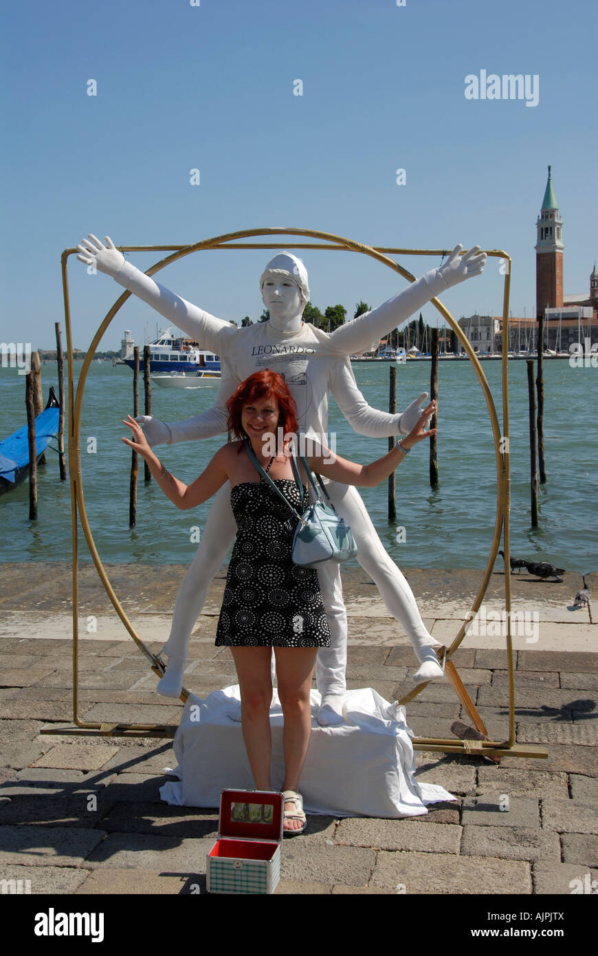 Girl tourist with street performer to recreate Leonardo Da Vinci's Vitruvian Man Venice Italy Stock Photo