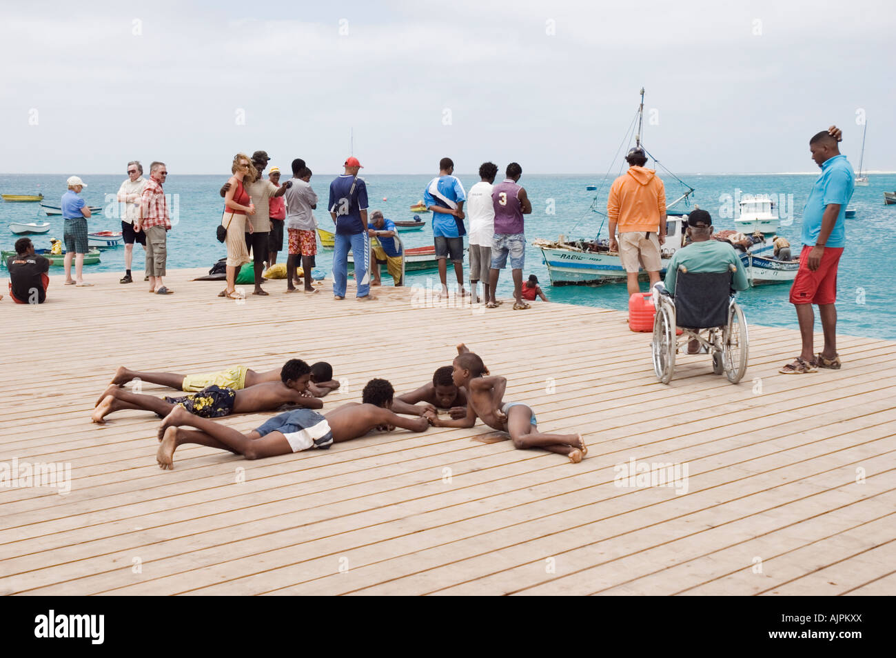 Colour landscape image of tourists and locals on the pier in 'santa maria', cape verde islands. Stock Photo