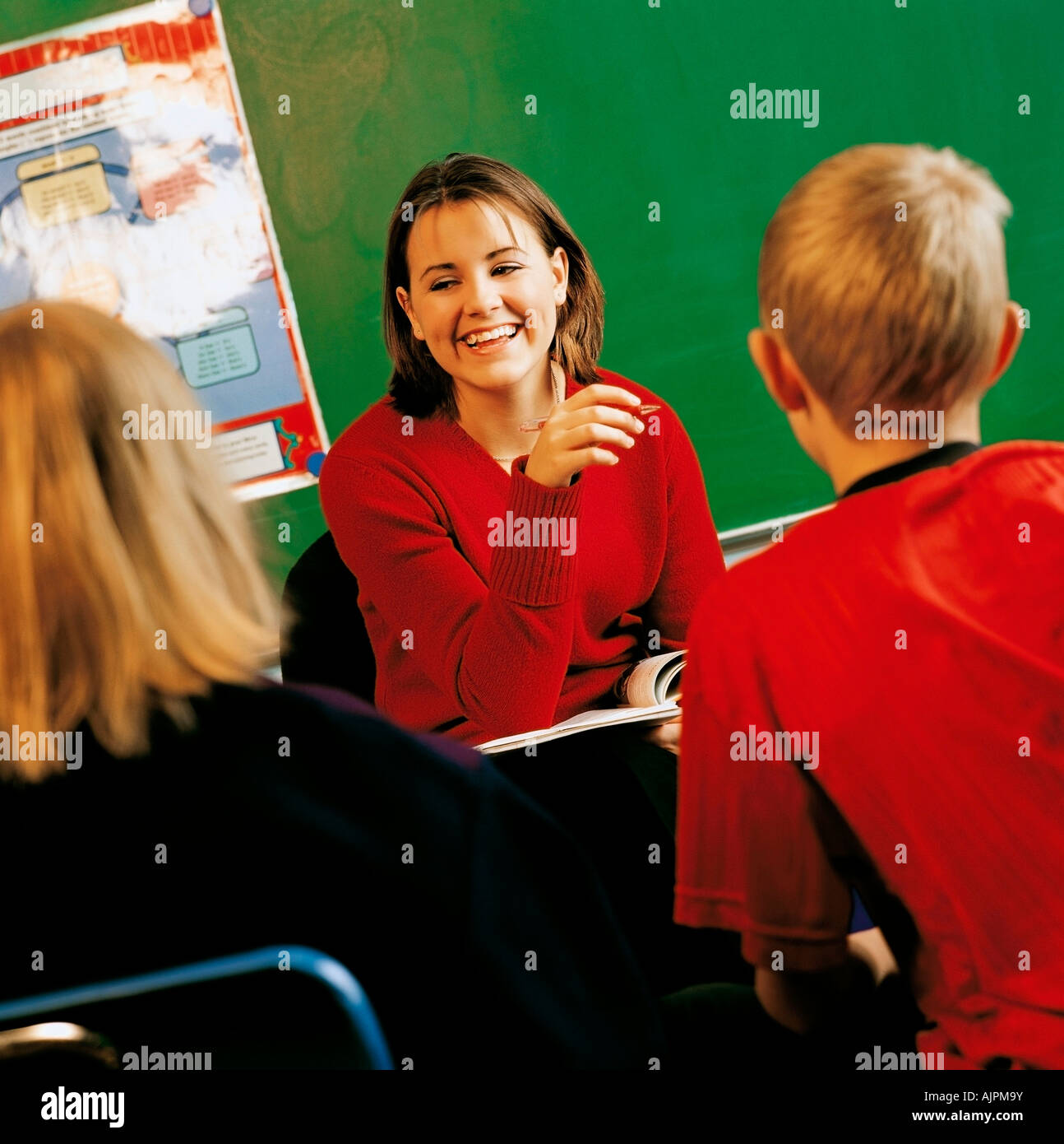 A teacher with students in a classroom Stock Photo