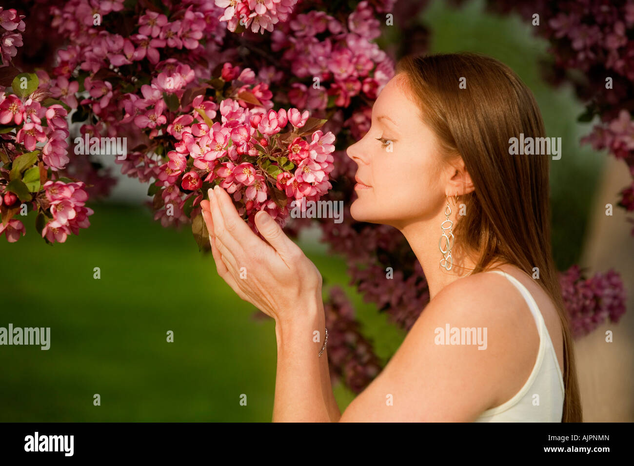 A young woman smelling flowers Stock Photo - Alamy