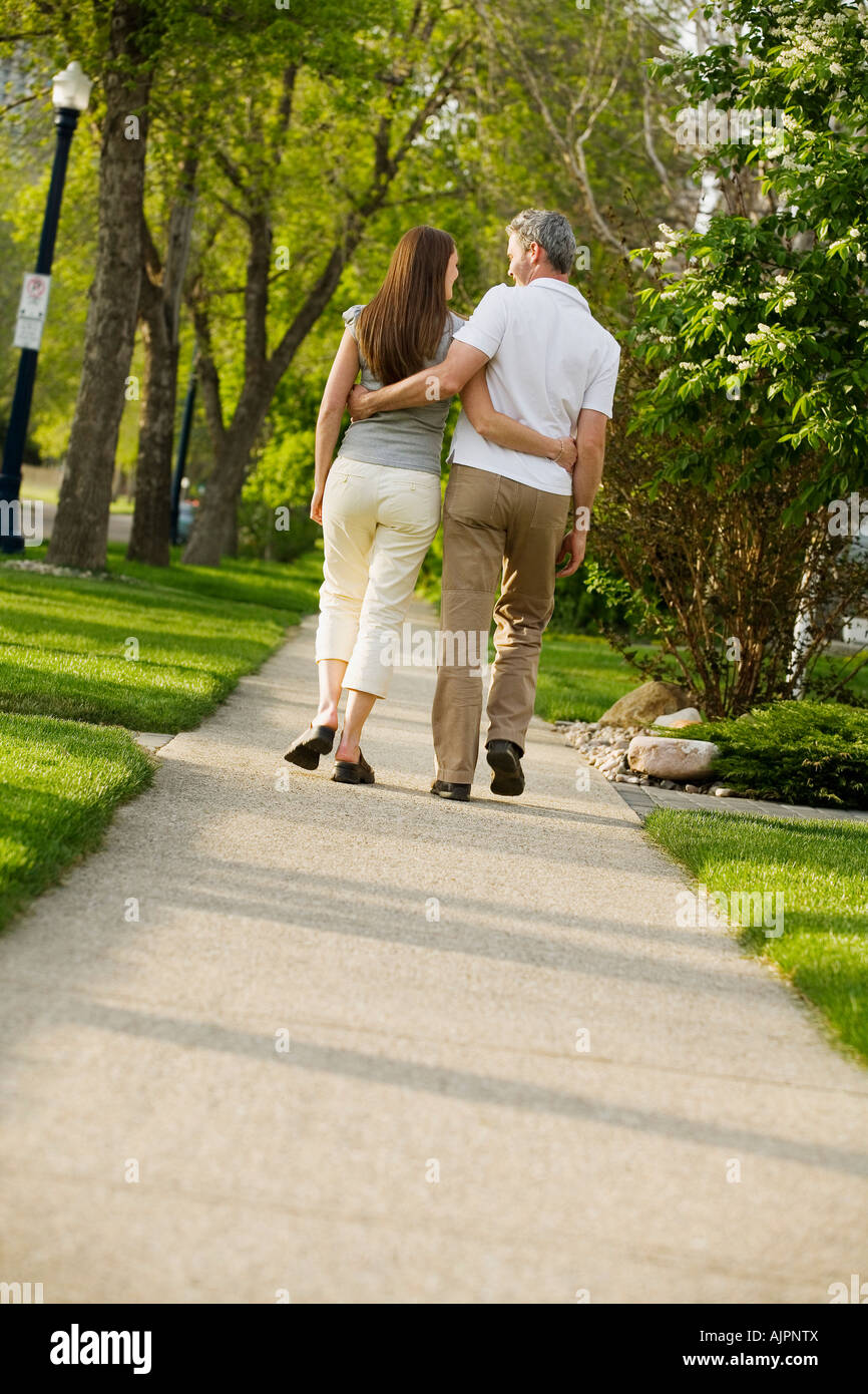 Rear view of a couple walking on pathway Stock Photo - Alamy