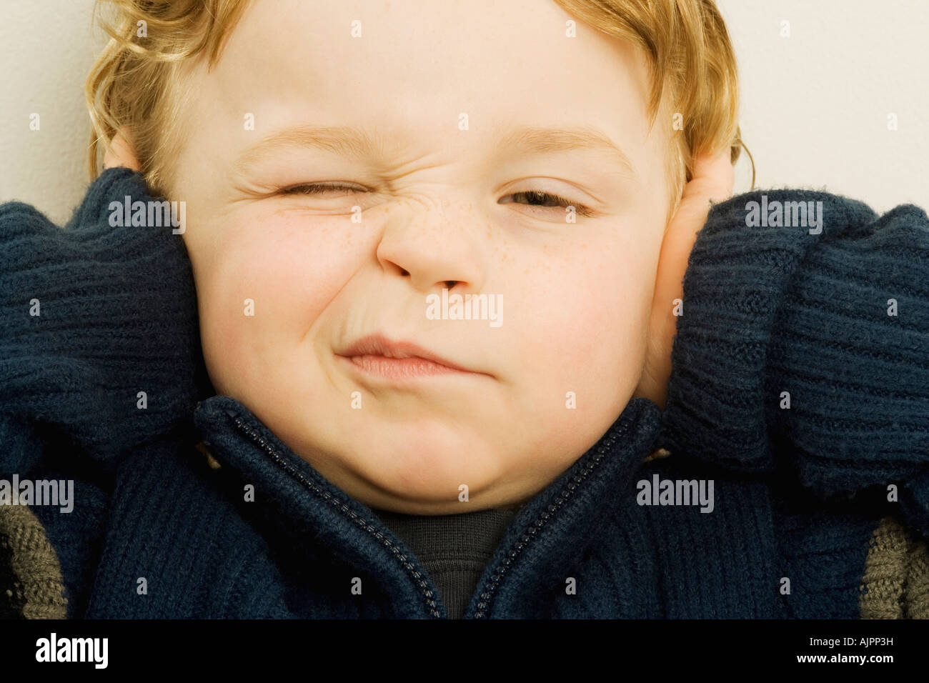 Boy with his hands over his ears Stock Photo Alamy