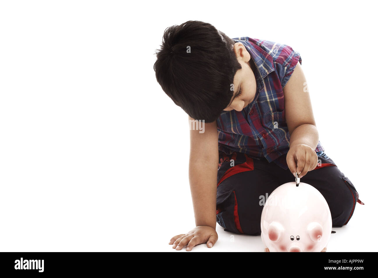 Portrait of a boy putting a coin into a piggy bank Stock Photo - Alamy