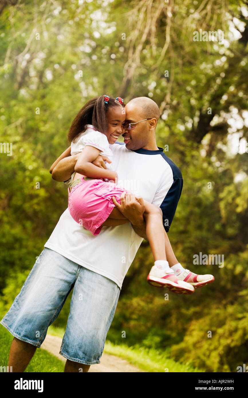 Father holding daughter in park Stock Photo - Alamy